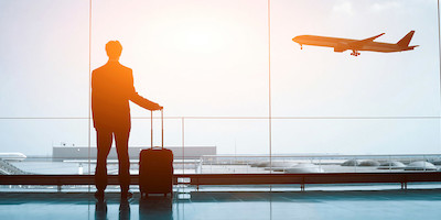 Lone Traveler with Suitcase Watching Planes at Sunrise